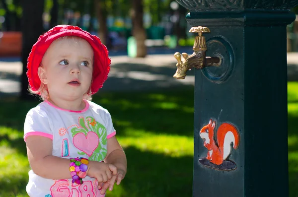 Park, açık musluk yanında akıllı şirin kız — Stok fotoğraf