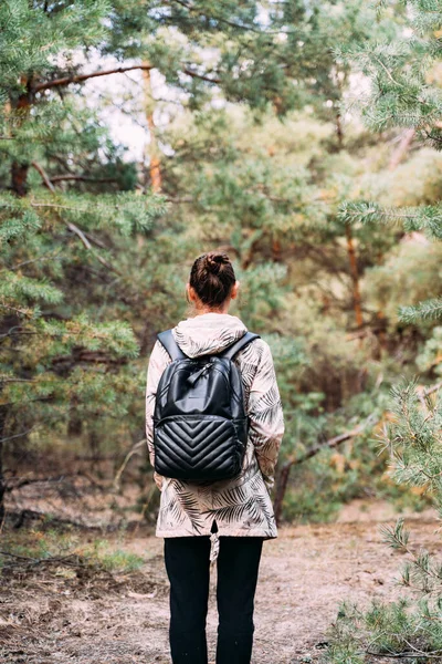 Una mujer en el bosque en un día soleado. Árboles altos de pino. Cerca de la naturaleza, sanación mental con aire fresco. Desintoxicación digital, desenchufado a la naturaleza. habilidades de supervivencia — Foto de Stock