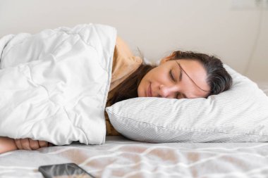 Genç bir kadın uykusuzluk çekerek telefon bağımlılığına giriyor. Uyumaya çalış. Telefondaki uyku takibi. Circadian ritmi.