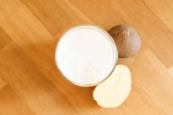 木製の背景にジャガイモのミルク写真。代替牛乳のガラス.植物由来のベジタリアン飲料。飲み放題 — ストック写真