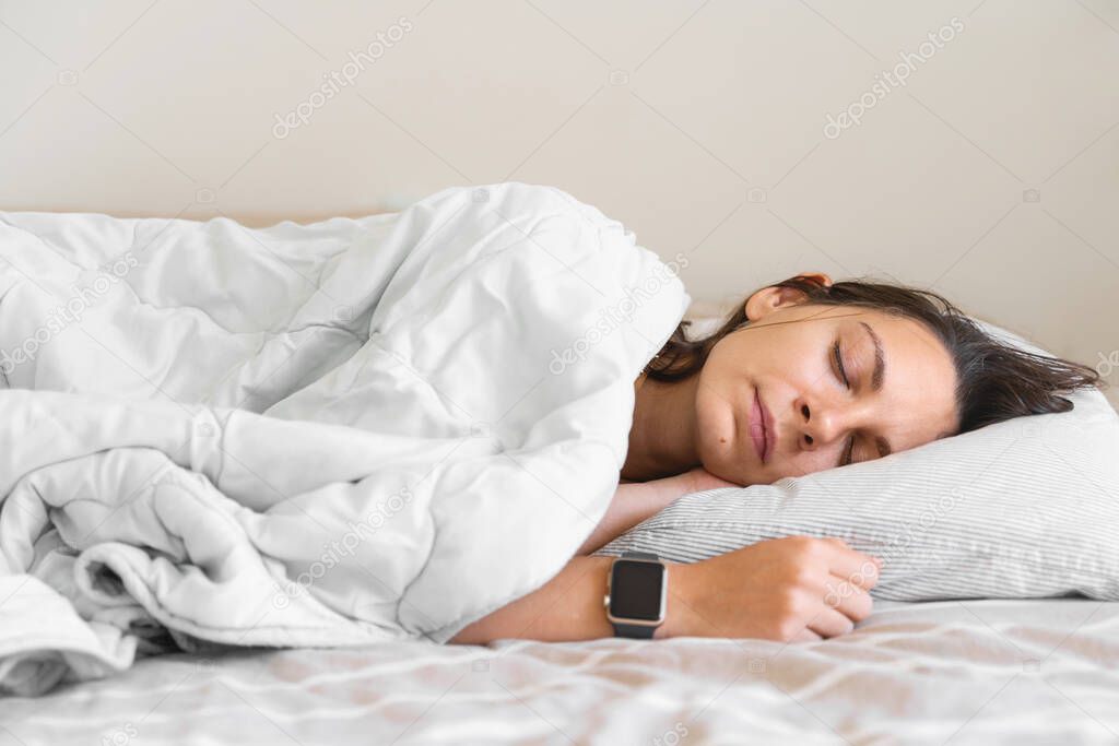 Young woman goes to sleep Phone addiction, insomnia. try to fall asleep. Sleep tracking on the phone and smart watch. Circadian rhythm.