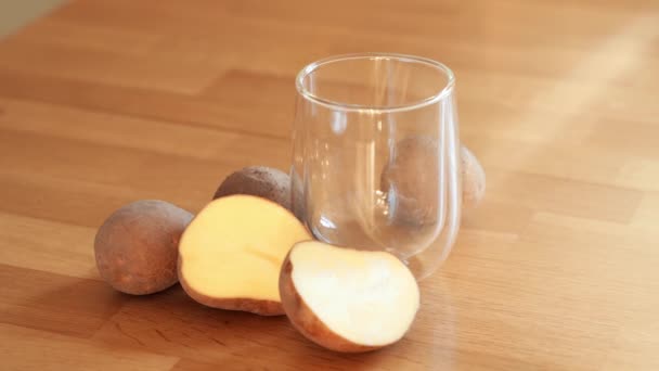 Kartoffelmilch Foto auf hölzernem Hintergrund. Glas mit alternativer Milch. Pflanzliches vegetarisches Getränk. Laktosefreies Getränk — Stockvideo