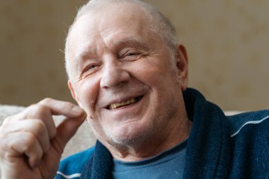 Son sınıf öğrencisinin el ele tutuşup hap içişini yakından izleyin. Emekli bir adamın yüzü ve eli buruşmuş. İlaveler, uzun yaşam konsepti