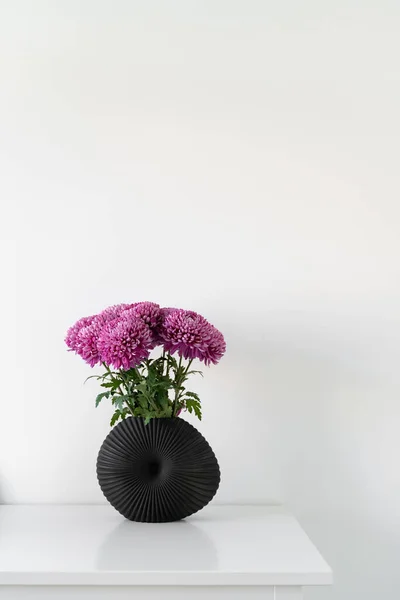 Composição elegante das belas flores de crisântemo rosa em pé em vaso moderno preto à mesa. Lagom Sueco Cultura conceito — Fotografia de Stock