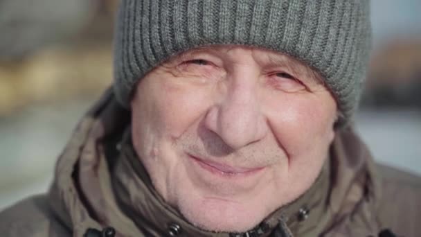 Biały, biały mężczyzna zamyka portret w zimowy słoneczny dzień. Trekking aktywny styl życia mężczyzna na emeryturze. Ręczny film wideo — Wideo stockowe