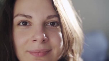 Evinde genç bir kadının mutlu gülümseyen portresi. Ağır çekim. Neşeli ve çekici biri.