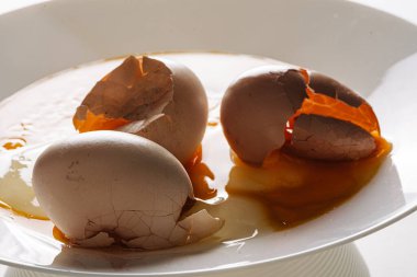 Sabah ışıklarıyla beyaz tabakta yumurta kırdım. Kırık yumurta kabuğu 