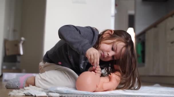 Menina da criança brinca com boneca como médico. Fingi brincar sozinho. — Vídeo de Stock