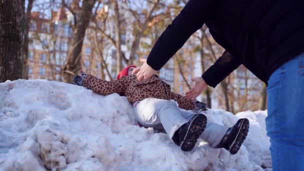 Caucasian happy preschool girl plays with father with snow on a sunny winter day in a park — Stock Video