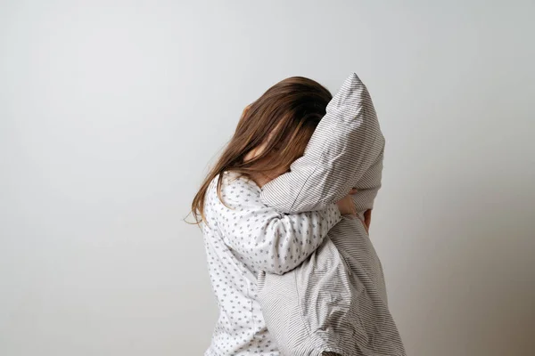 화이트 피 자마를 입은 예쁜 코카서스 여자의 모습 과하얀 배경의 스튜디오에 있는 베개 — 스톡 사진