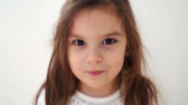 Komik anaokulu kızı, aptal suratlar yapıyor. Duygularıyla samimi bir çocuk portresi yapıyor. 