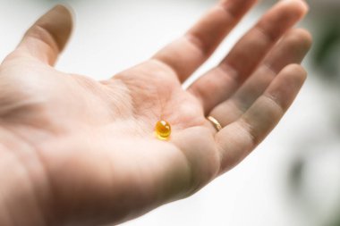 Avuç dolusu sarı softball topu yakın çekim. Takviye almak, D vitamini ya da omega. Refah biyohack konsepti