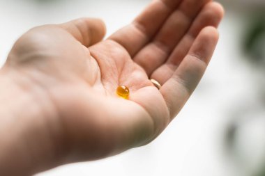 Avuç dolusu sarı softball topu yakın çekim. Takviye almak, D vitamini ya da omega. Refah biyohack konsepti