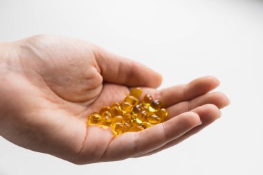 Avuç dolusu sarı softball topu yakın çekim. Takviye almak, D vitamini ya da omega. Refah biyohack konsepti