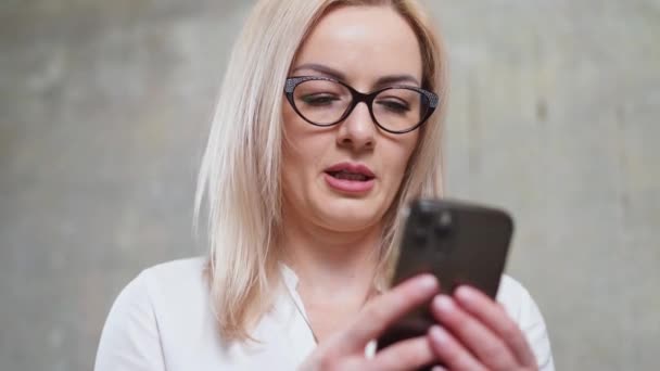 Vit kvinna med smartphone i händerna, vacker affärskvinna med glasögon på kontoret — Stockvideo