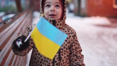 Ukraynalı çocuk, Ukrayna, Poltava 'da ülke bayrağıyla geziyor. Avrupa 'da mülteci krizi. Rus ordusu işgali, savaşı durdurun.
