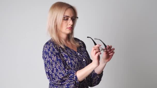 Kavkazská krásná žena s blond vlasy zkouší různé brýle. Koncept obchodu s brýlemi. Špatné vidění zdravotní problém — Stock video
