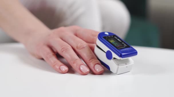 指に酸素濃度計で女性の手を閉じます.血中酸素飽和度計. — ストック動画