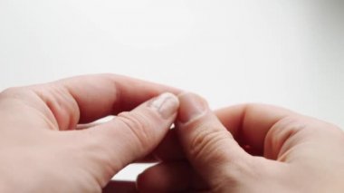 Kadın elinin kırılgan tırnaklarını kapat. Beyaz arka plan. Kırık ve kuru tırnak. Avitaminoz ve mikro element açıkları 