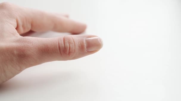 Närbild av sköra naglar på kvinnlig hand. Vit bakgrund. Bruten och torr nagel. Brister i avitaminos och mikroelement — Stockvideo
