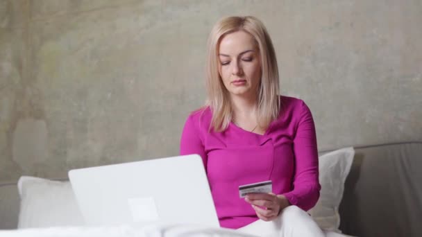 Biała, piękna kobieta na łóżku z laptopem i kartą kredytową. Bezpieczeństwo płatności online, błąd zakupu — Wideo stockowe