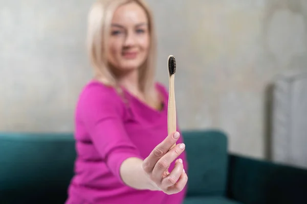 Primer plano de la mano de la mujer con cepillo de dientes de bambú. Cepillo reciclable ecológico de bambú. Concepto de cero residuos — Foto de Stock
