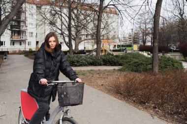 Bisiklet kiralama servisinde bisiklet süren genç bir kız. Hayat tarzı, turist gibi bisiklet kiralayan bir kız öğrenci.