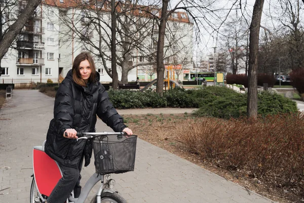 Bisiklet kiralama servisinde bisiklet süren genç bir kız. Hayat tarzı, turist gibi bisiklet kiralayan bir kız öğrenci.