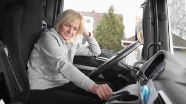Beyaz, orta yaşlı bir kadın kamyon kullanıyor. Kamyoncu kadın işçi, taşımacılık endüstrisi işgali. 