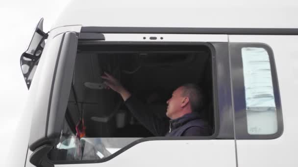 Homem caucasiano de meia idade motorista de caminhão. Alemanha emprego para a Europa camionista de transportes. Cabine do camião de carga — Vídeo de Stock