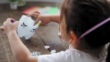 Kafkasyalı anaokulu kızı plastik şişe ve boyalarla el işi yapıyor. Geri dönüşüm atıkları. Sürdürülebilir yaşam tarzı