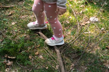 Close up of child girl legs in forest. Hiking with children on nature, outdoors trail for kids. Health and sport of hikers