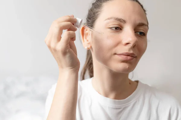 Közelkép fehér nő kezét alkalmazó olaj illóolaj vagy szérum a bőr. Az önellátás fogalma — Stock Fotó