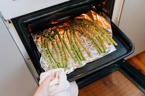 Green Asparagus sprouts on frying pen in kitchen. Grilled fresh vegetables — Stock Fotó