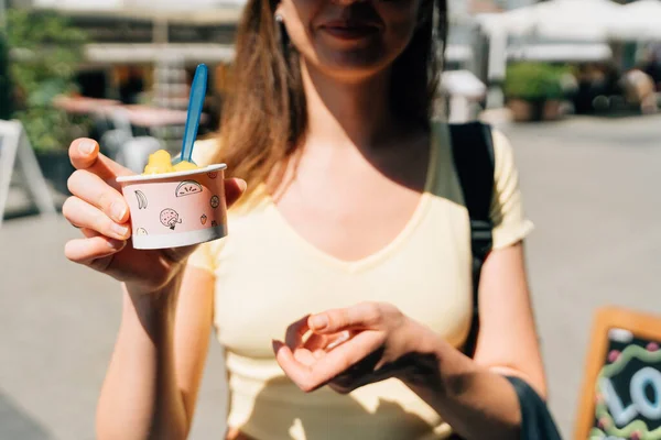 Close up of teen girl with paper cup with mango yellow sorbet ice cream on sunny summer day — Stock Photo, Image