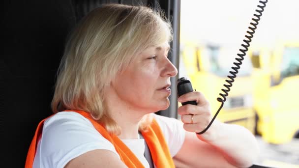 Női kamionsofőr beszél rádión a kabinban. Női kamionos munkás — Stock videók