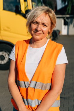 Sarı kamyonetin önünde gülümseyen orta yaşlı mutlu bir kadın. Yüksek kalite fotoğraf