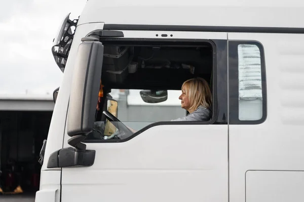 Caucasian mid age woman driving truck. trucker female worker, transport industry occupation . High quality photo