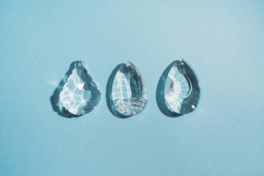 Three crystals with light refraction on blue minimal background . High quality photo