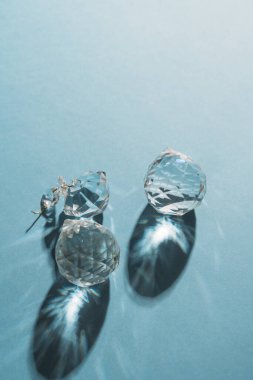 Three crystals with light refraction on blue minimal background . High quality photo