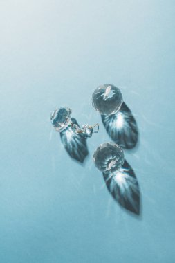Three crystals with light refraction on blue minimal background . High quality photo