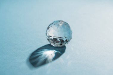 One crystals with light refraction on blue minimal background . High quality photo