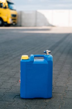 Blue fuel canister or gasoline outdoors on truck parking, energy crisis concept. High quality photo