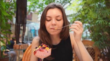 Young woman portrait eating ice cream in a cafe in tropics . High quality FullHD footage