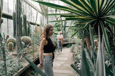 Two woman in a greenhouse full of cactuses. Plant garden for tourists . High quality photo