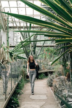 Young woman in a greenhouse full of cactuses. Plant garden for tourists . High quality photo