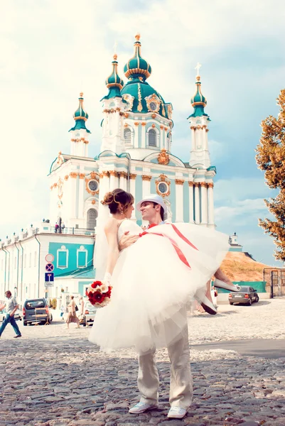Noiva e noivo, sentados perto de uma igreja — Fotografia de Stock