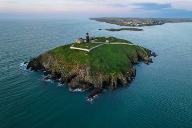 İrlanda 'nın Cork ilçesindeki Ballycotton deniz fenerinin hava manzarası sakin bir sonbahar sabahında gün doğumunda