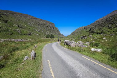 People trekking at The Gap of Dunloe, a narrow mountain pass running north south in County Kerry, Ireland