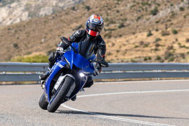 Asfaltta yatan bir motosikletli. Fotoğraf 26 Ekim 2020 'de Avila, Spai' deki Navalmoral limanında çekildi.